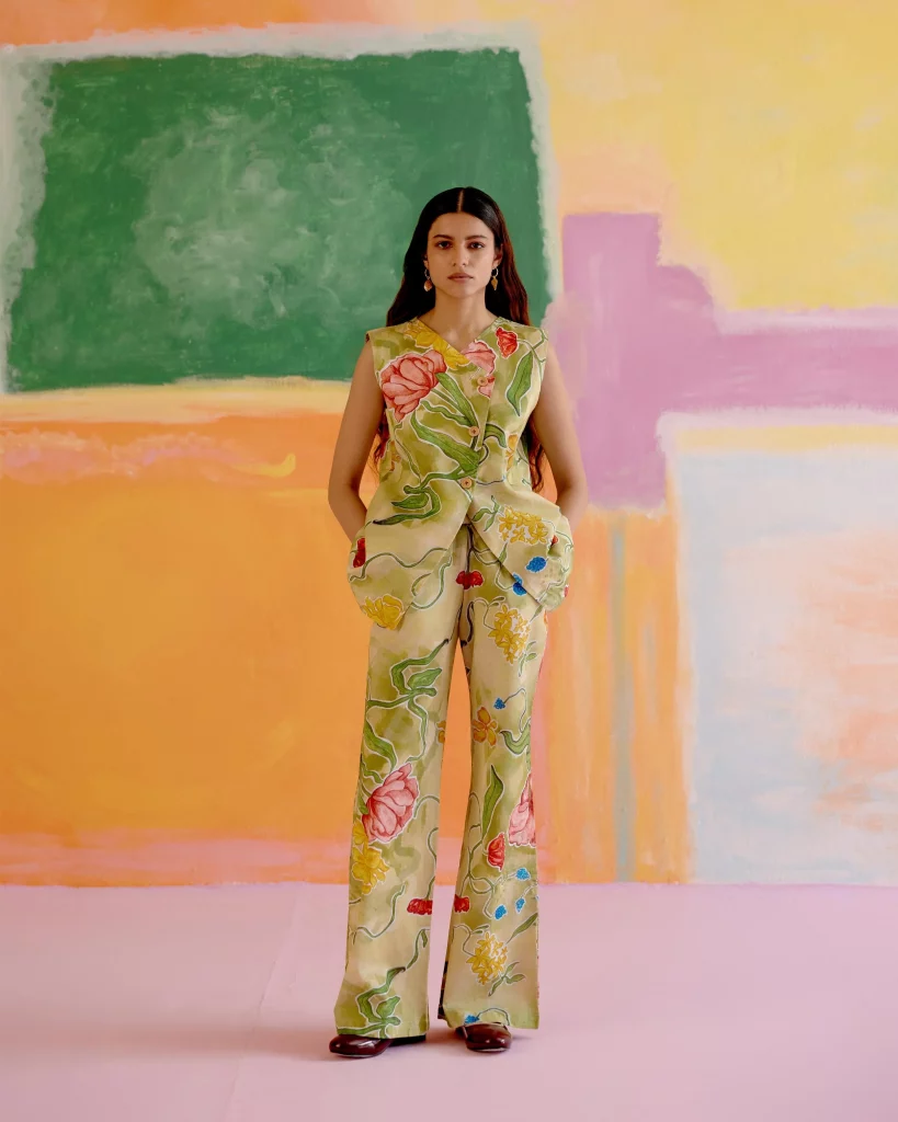 The image displays a woman wearing a co-ord set with a Le Jardin print that features floral and leafy motifs in soft, natural tones. Copyright Happï Space.