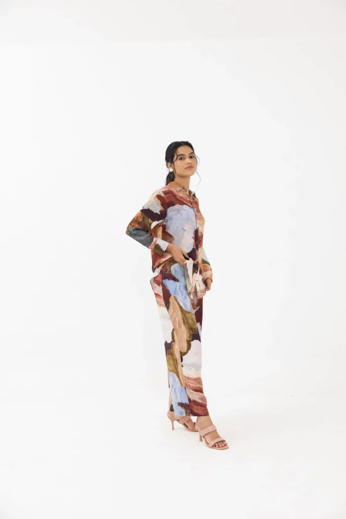 The image displays a woman wearing a co-ord set with a painting-like pattern. Copyright THR3LETTER.