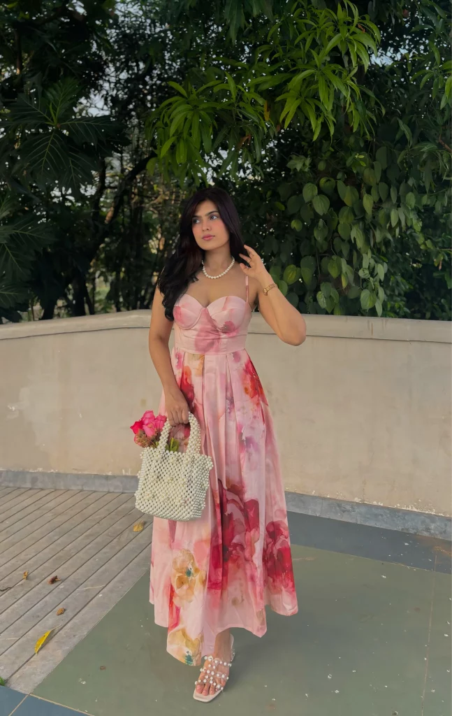 The image displays a woman wearing a pastel rose-colored maxi dress. Copyright THR3LETTER.