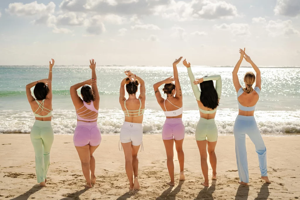 The image displays women at the beach with different body shape types including hourglass, triangle, inverted triangle, oval, and rectangle. Copyright FbyF Studio/Pexels.