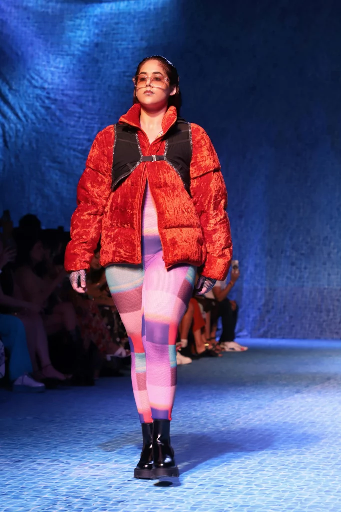The image displays a woman wearing a vest, jacket, bodysuit, boots, and sunglasses. Copyright Rajesh Kumar Verma/Pexels.
