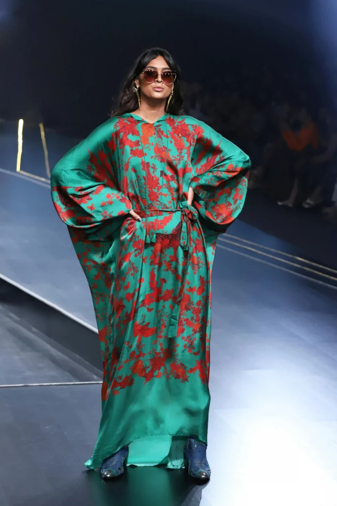 The image displays a woman wearing a kaftan dress, cowboy boots, sunglasses, and jewelry. Copyright Rajesh Kumar Verma/Pexels.